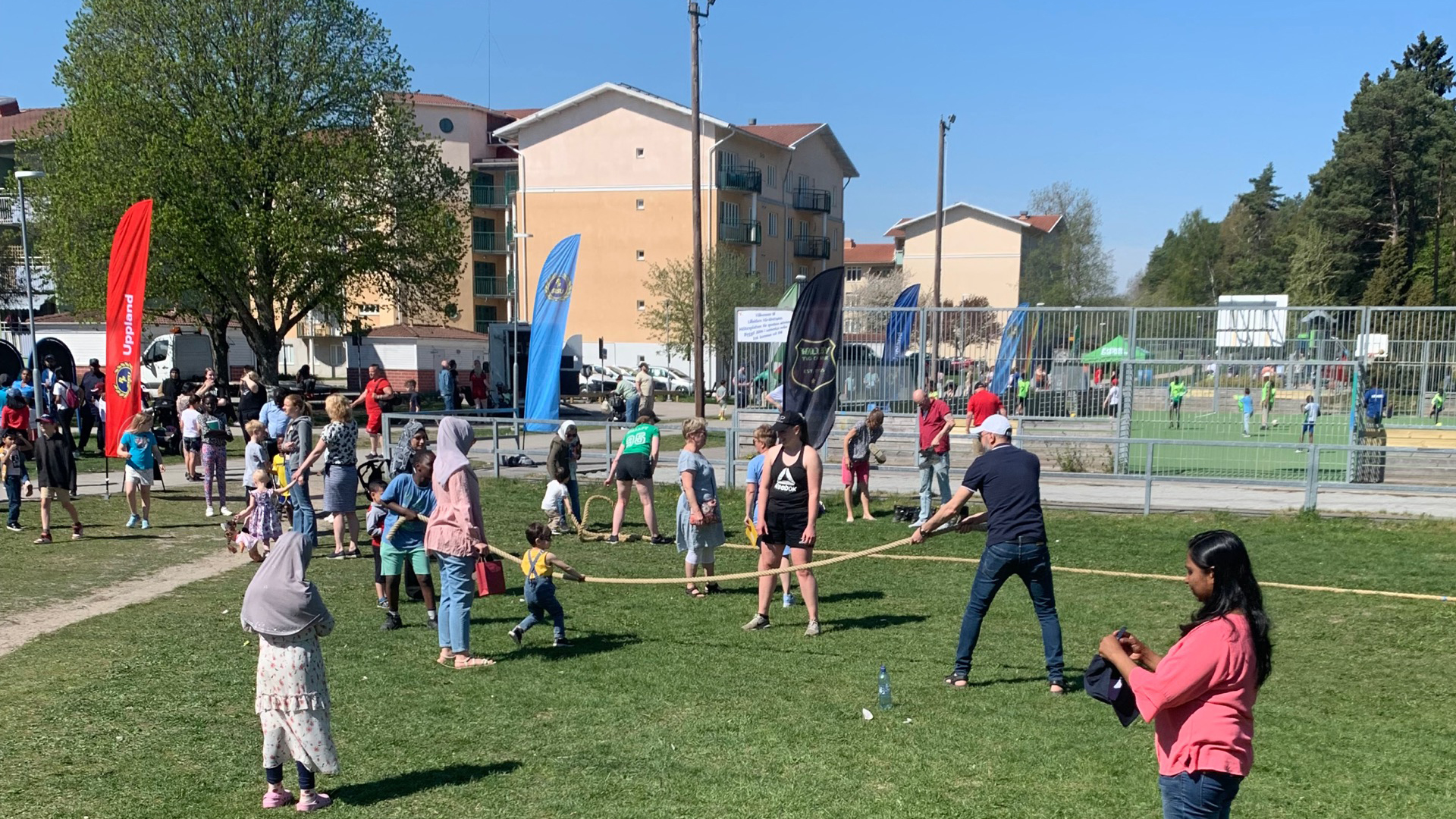 Besökare som provar på dragkamp på gräsplanen