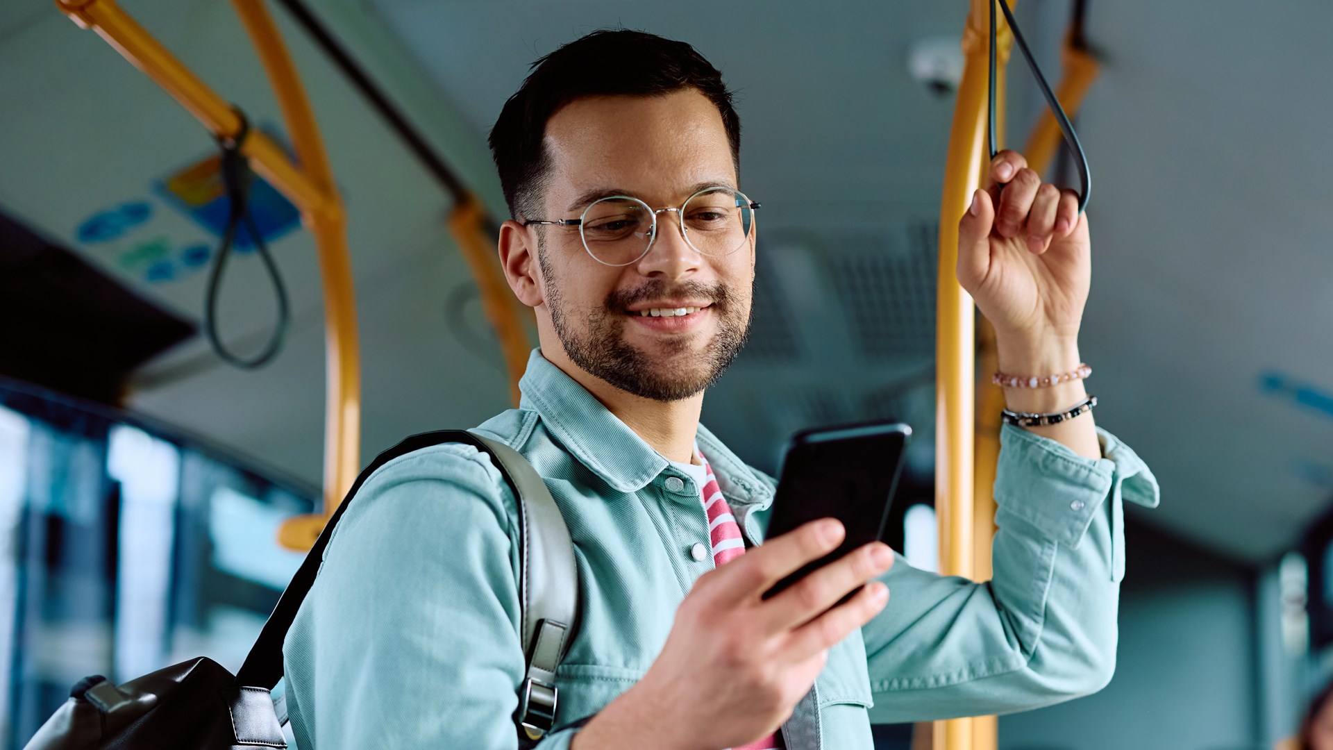 Man med mobiltelefon på en buss