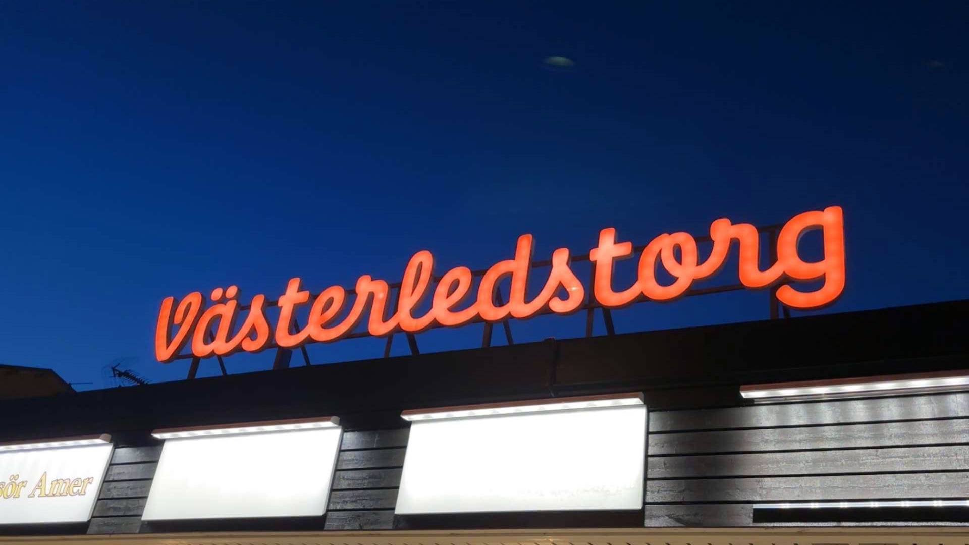 Skylt i orange med text Västerledstorg