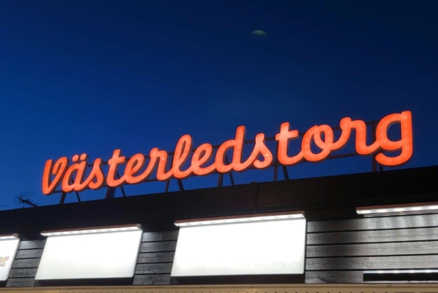 Skylt i orange med text Västerledstorg