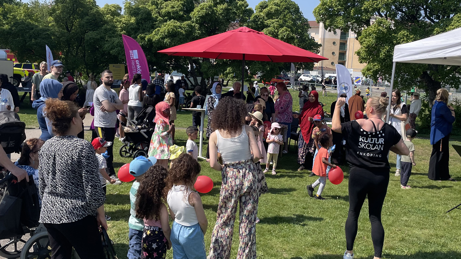 Folksamling på en gräsyta med eventtält